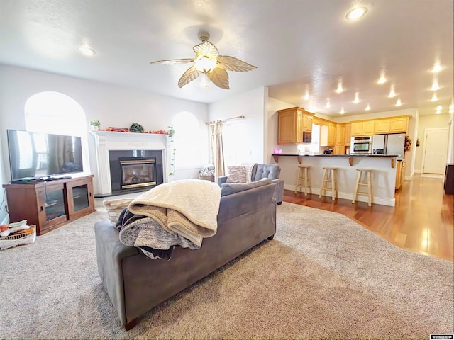 living room with ceiling fan and light hardwood / wood-style floors