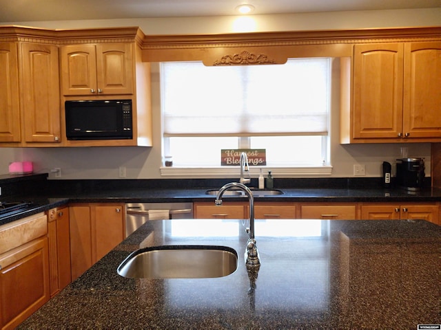 kitchen featuring dishwasher, black microwave, sink, and dark stone counters