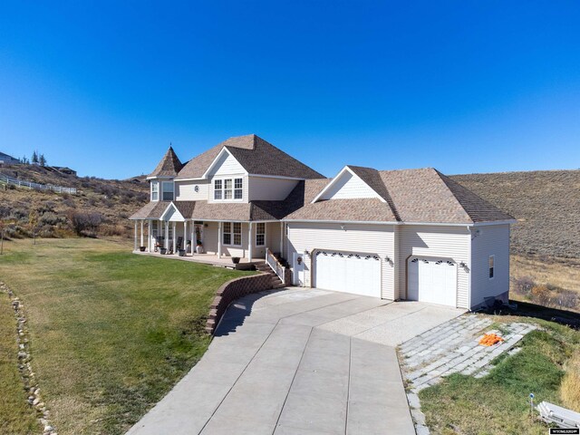 view of front of house featuring a garage, a front lawn, and a porch