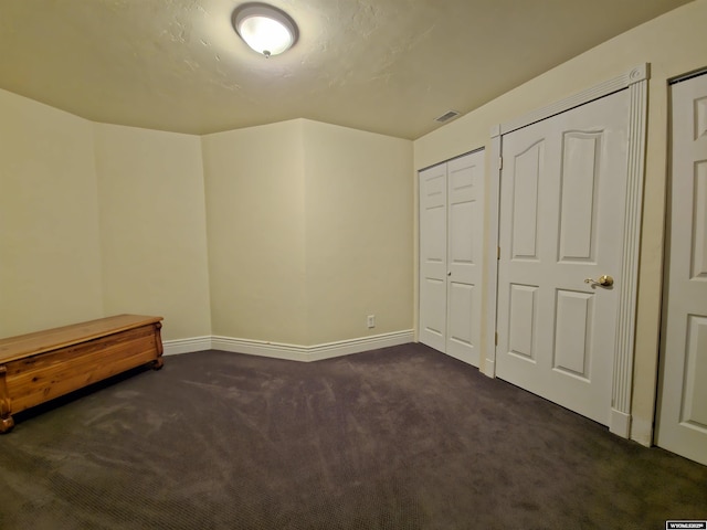 unfurnished bedroom featuring dark colored carpet