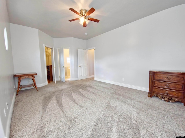 unfurnished bedroom featuring ensuite bathroom, a spacious closet, ceiling fan, light carpet, and a closet