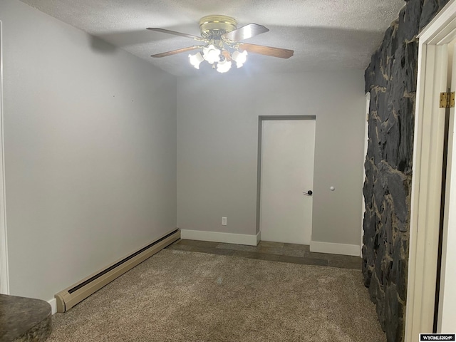 spare room featuring baseboard heating, dark carpet, ceiling fan, and a textured ceiling