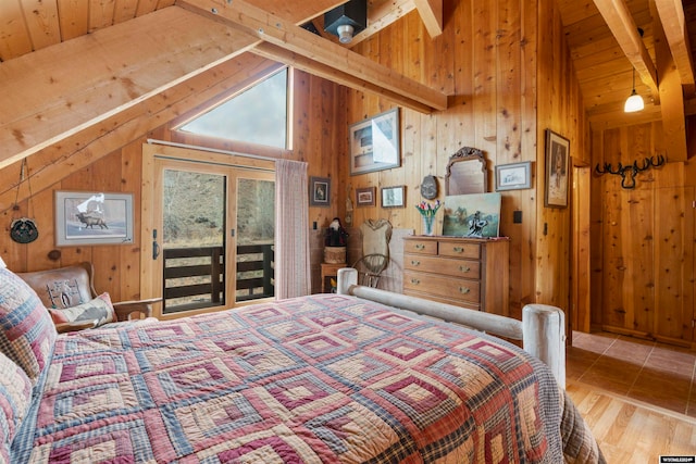 bedroom featuring wood walls, lofted ceiling with beams, hardwood / wood-style flooring, and access to exterior