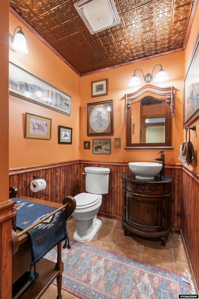 bathroom with ornamental molding, toilet, tile flooring, and vanity