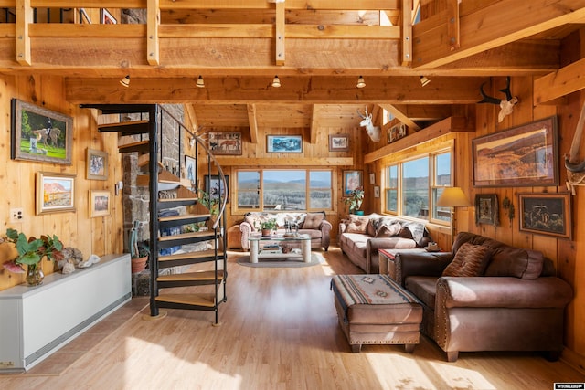 living room with beamed ceiling, light hardwood / wood-style flooring, and wooden walls