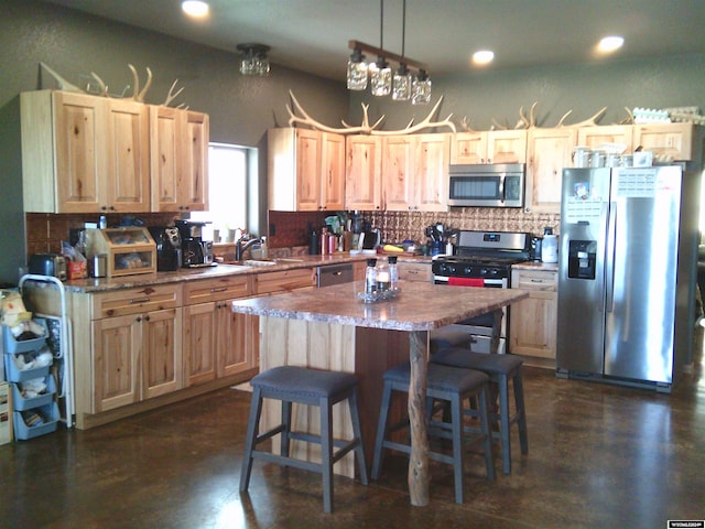 kitchen featuring light brown cabinets, backsplash, stainless steel appliances, a kitchen breakfast bar, and a center island