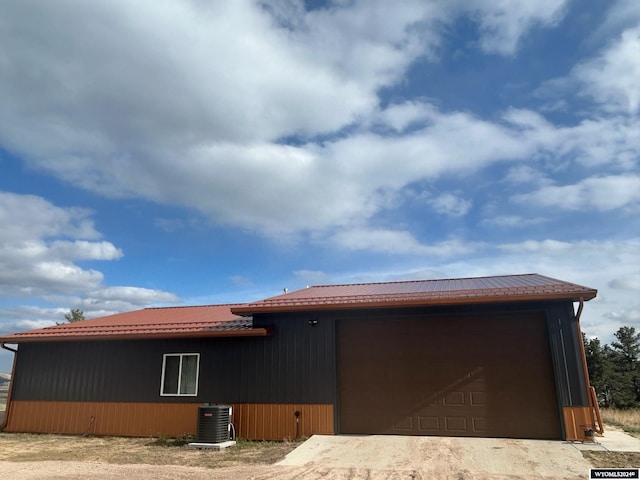 view of front of home with a garage and central air condition unit