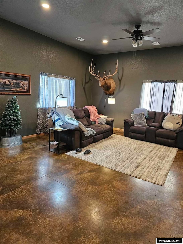 living room featuring a textured ceiling, a wealth of natural light, and ceiling fan