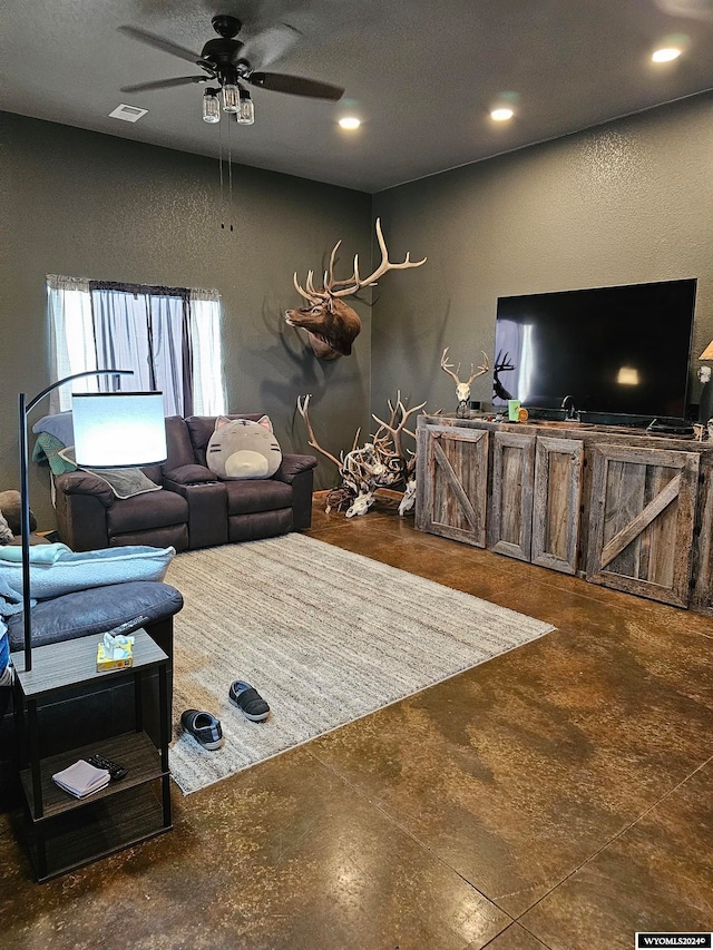 living room featuring dark tile flooring, ceiling fan, and a textured ceiling