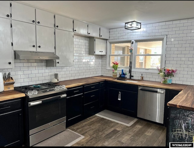 kitchen with sink, wood counters, white cabinetry, and stainless steel appliances