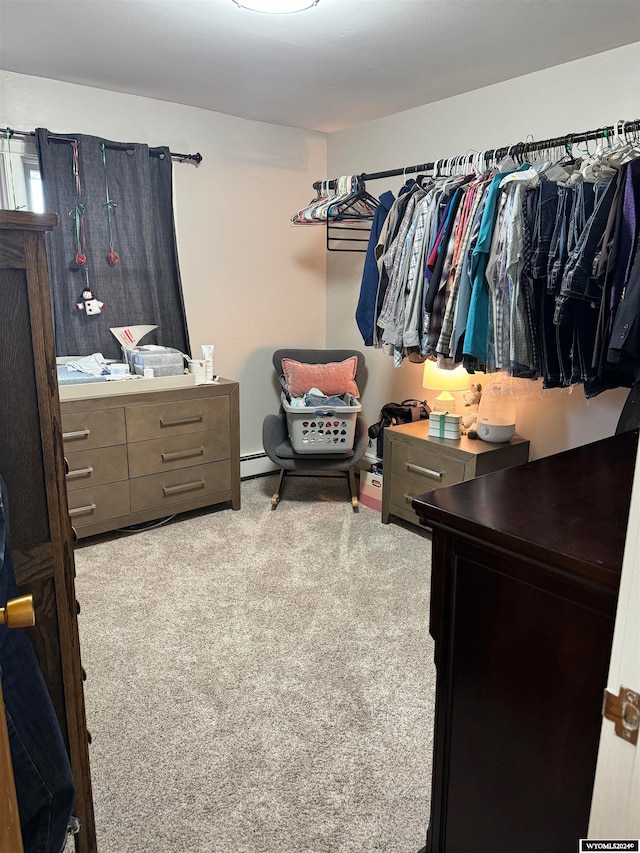 walk in closet with light carpet and a baseboard heating unit