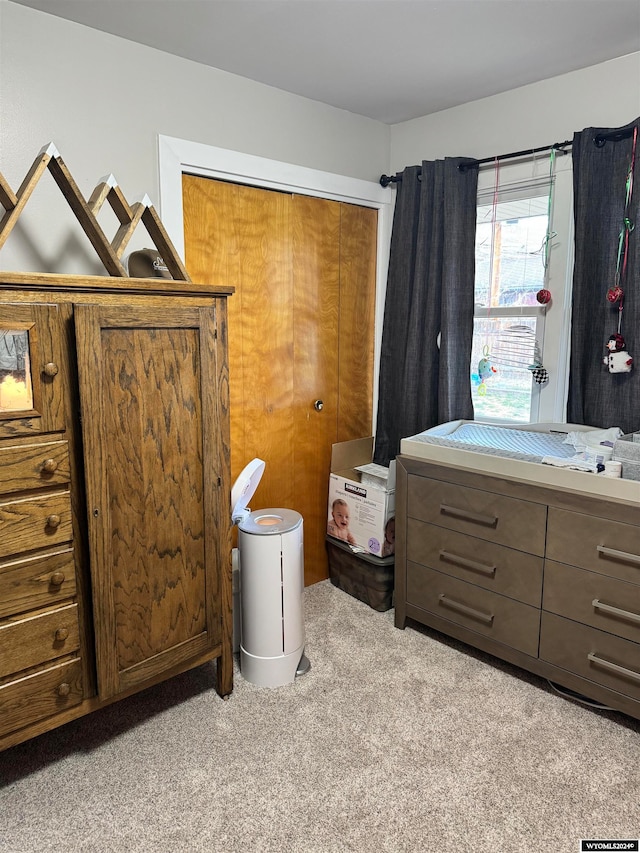 bedroom with light carpet and a closet