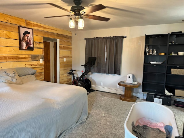 carpeted bedroom with wood walls, ceiling fan, and baseboard heating