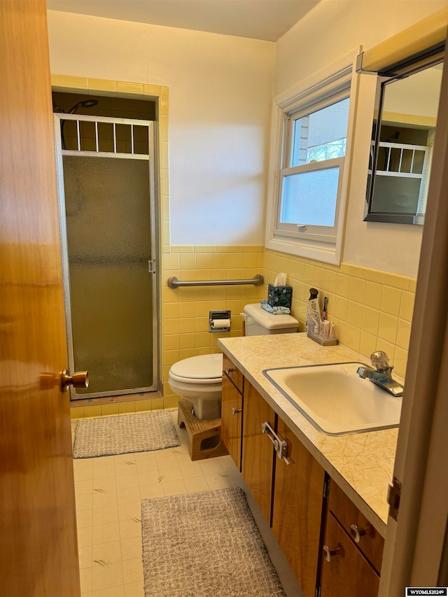 bathroom with vanity with extensive cabinet space, tile floors, tile walls, backsplash, and toilet