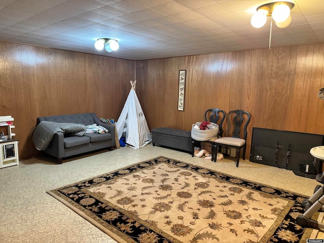 rec room with carpet flooring and wooden walls