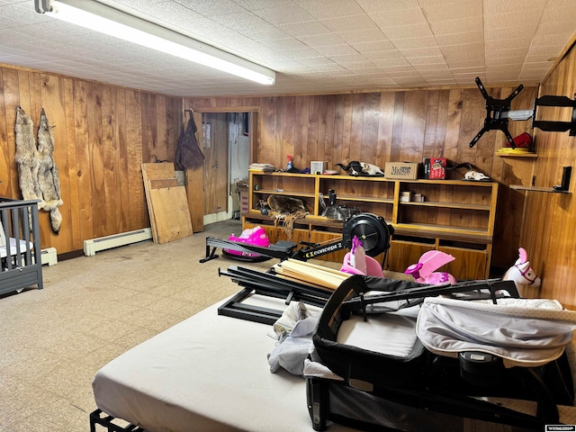 interior space with wooden walls, tile floors, and a baseboard heating unit