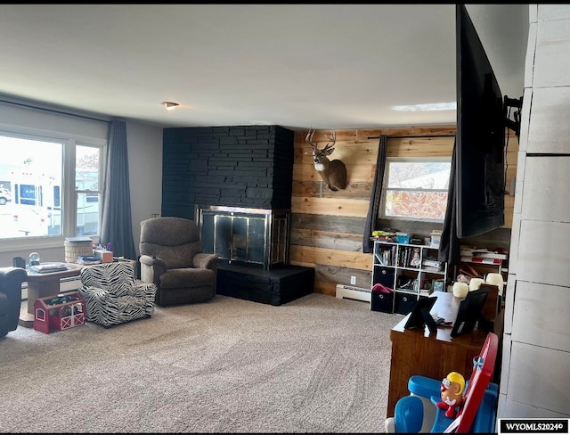 interior space with a baseboard radiator, carpet, a multi sided fireplace, and wooden walls