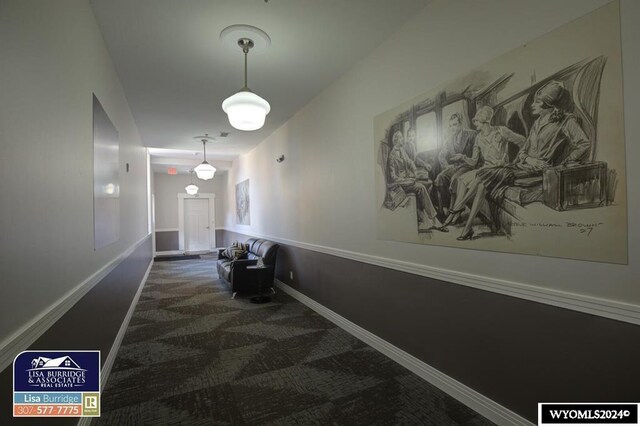 corridor featuring dark colored carpet