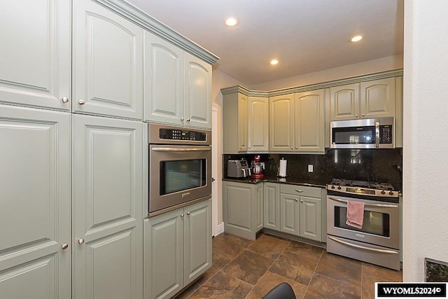 kitchen featuring dark tile flooring, tasteful backsplash, and stainless steel appliances