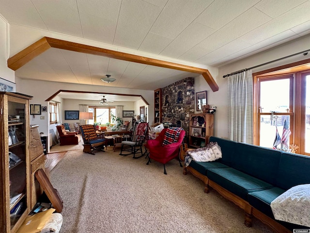 living room with beam ceiling, ceiling fan, and carpet floors