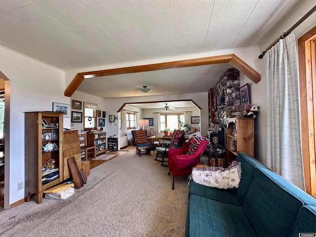 living room with a textured ceiling, ceiling fan, and carpet floors