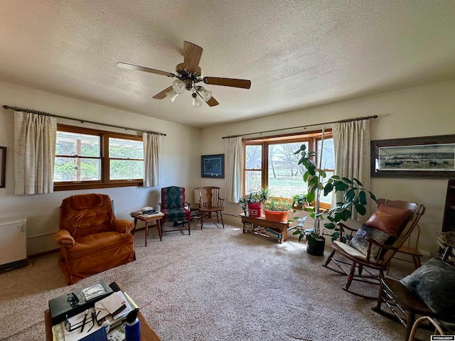 sitting room featuring a healthy amount of sunlight, carpet, ceiling fan, and a textured ceiling