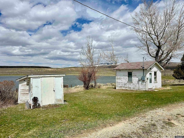 view of yard with a storage unit and a water view