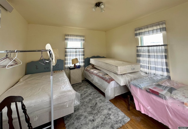 bedroom with hardwood / wood-style flooring and multiple windows