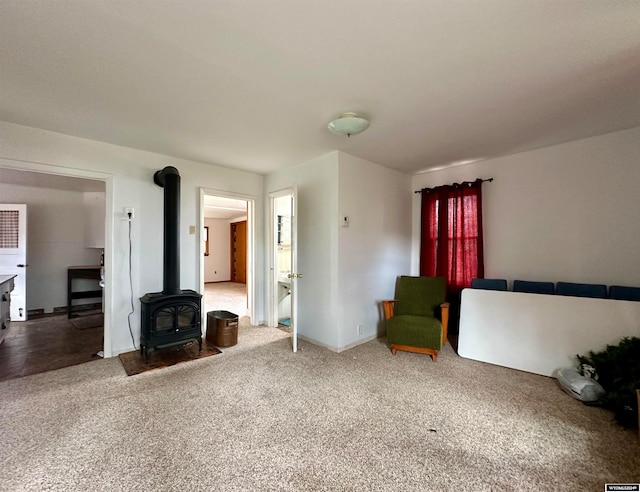 unfurnished room featuring a wood stove and carpet