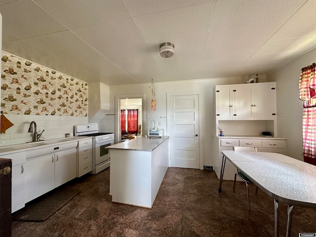 kitchen featuring white range with gas cooktop, dark tile floors, sink, backsplash, and white cabinetry