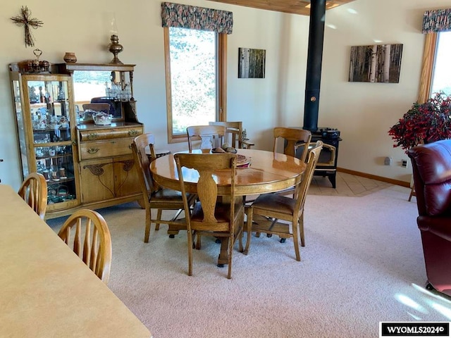 dining room with carpet flooring and a wood stove