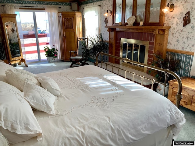 carpeted bedroom with a fireplace and multiple windows