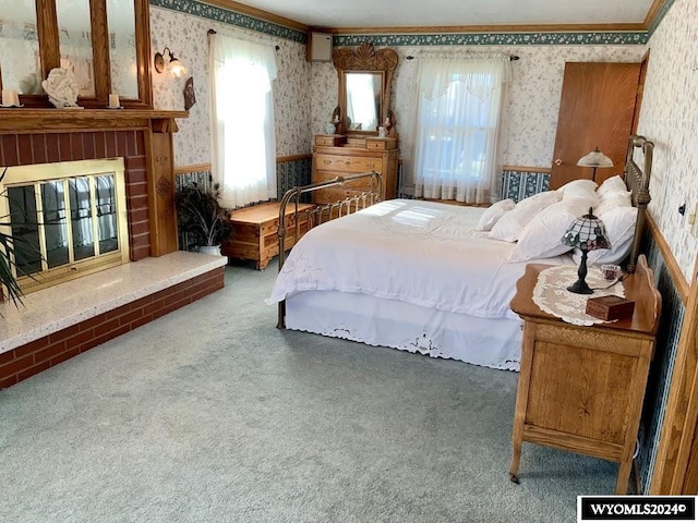 carpeted bedroom featuring crown molding and a brick fireplace