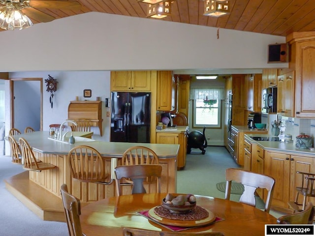 carpeted dining room featuring wooden ceiling, lofted ceiling, and ceiling fan