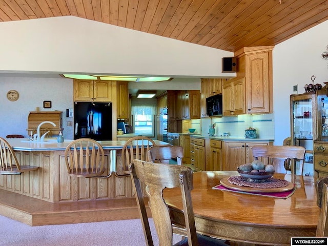 dining room featuring sink, vaulted ceiling, light colored carpet, and wood ceiling