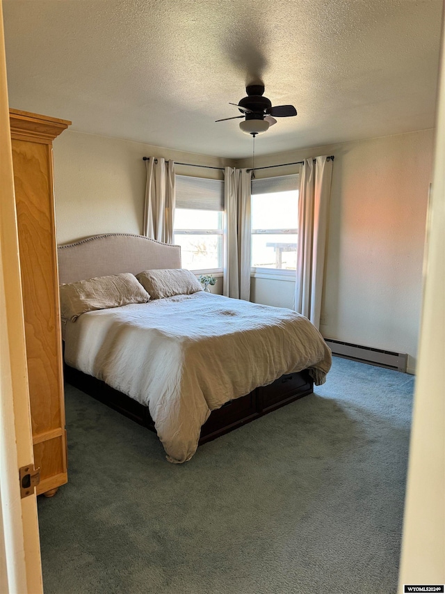 bedroom with a baseboard heating unit, a textured ceiling, ceiling fan, and dark carpet