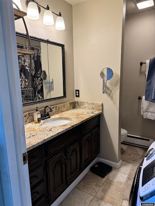 bathroom with tile flooring, a baseboard radiator, vanity, and toilet