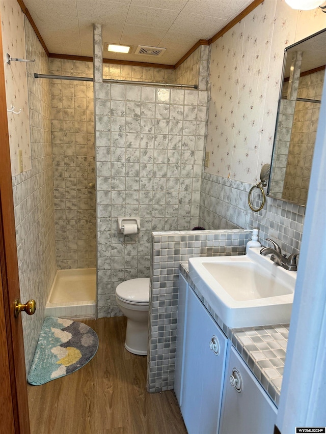 bathroom with vanity with extensive cabinet space, tile walls, toilet, and hardwood / wood-style floors