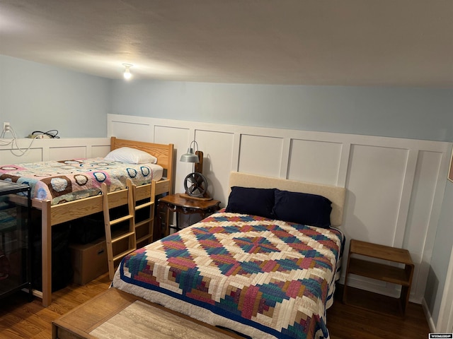 bedroom with vaulted ceiling and hardwood / wood-style floors