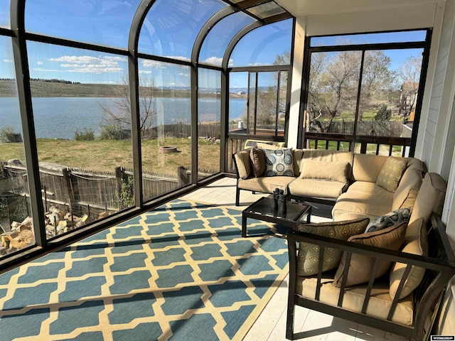 sunroom featuring a water view