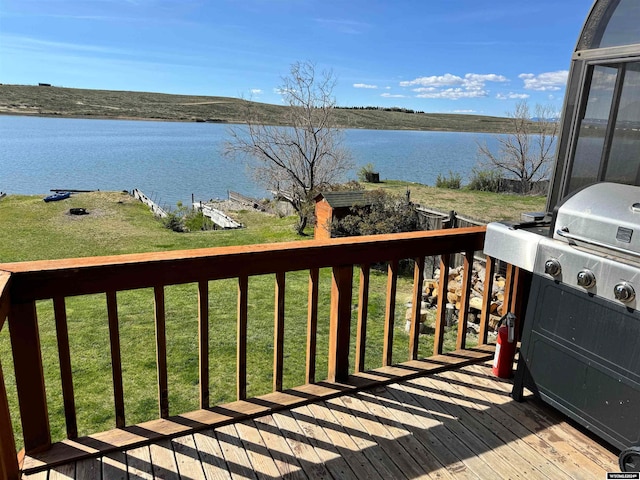 wooden terrace with a yard, a water view, and area for grilling