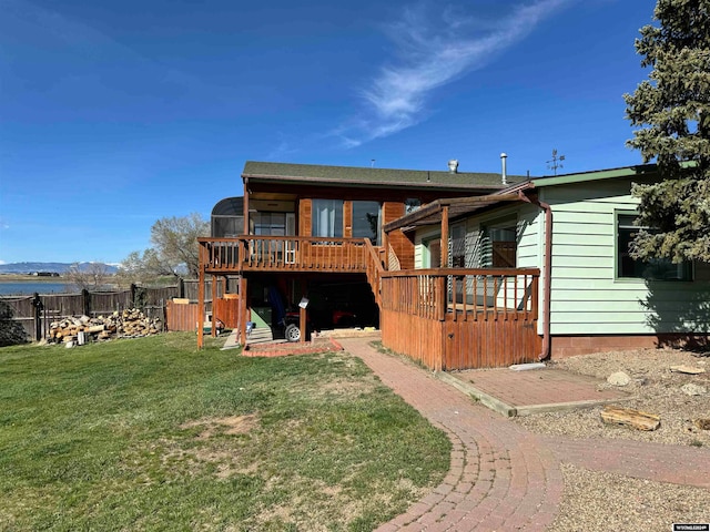 rear view of house featuring a deck and a lawn