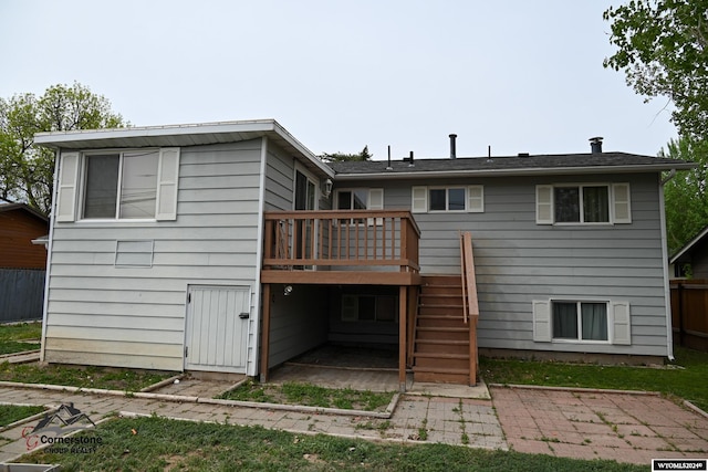 rear view of property featuring a wooden deck and a patio area