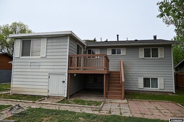 rear view of house featuring a wooden deck and a patio