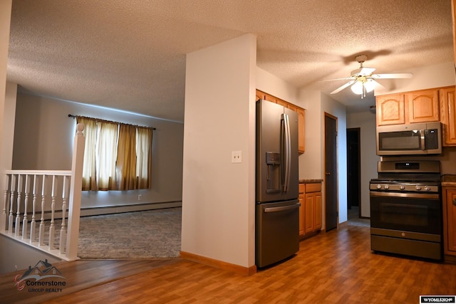 kitchen featuring stainless steel appliances, dark hardwood / wood-style floors, a textured ceiling, and a baseboard heating unit