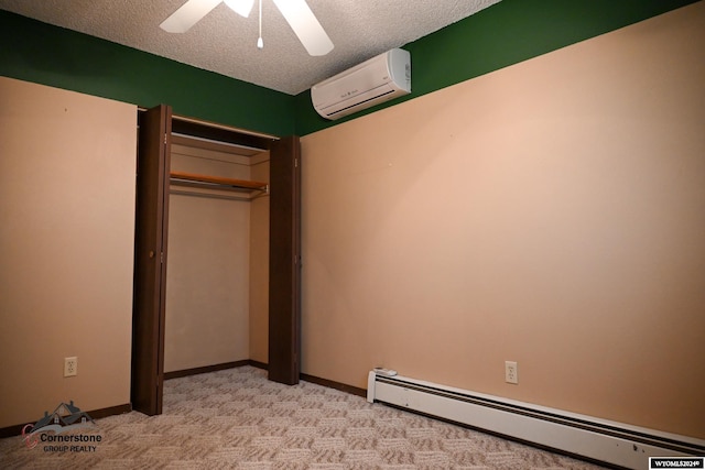 unfurnished bedroom featuring ceiling fan, a baseboard heating unit, a wall mounted AC, a textured ceiling, and a closet