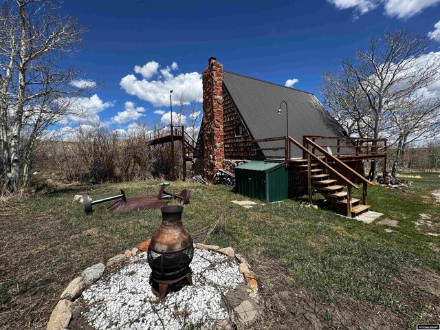 view of yard featuring a deck and a fire pit