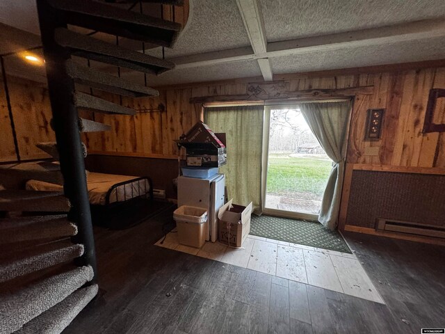 foyer with a baseboard radiator, coffered ceiling, hardwood / wood-style flooring, beam ceiling, and wooden walls