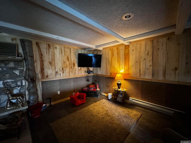 interior space with beamed ceiling, baseboard heating, dark hardwood / wood-style flooring, and a textured ceiling