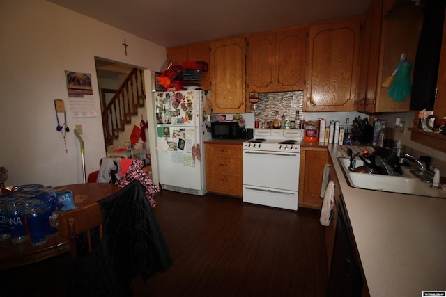 kitchen with dark hardwood / wood-style floors, white appliances, and sink